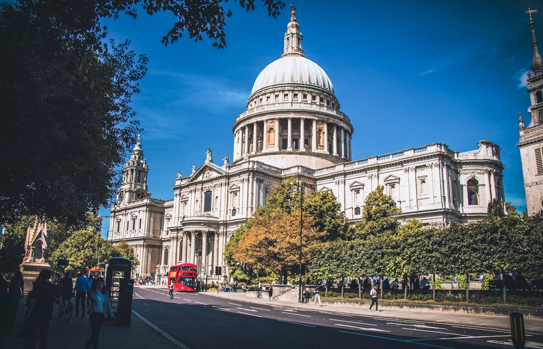 St Paul's Cathedral in London with red double-decker bus passing by.