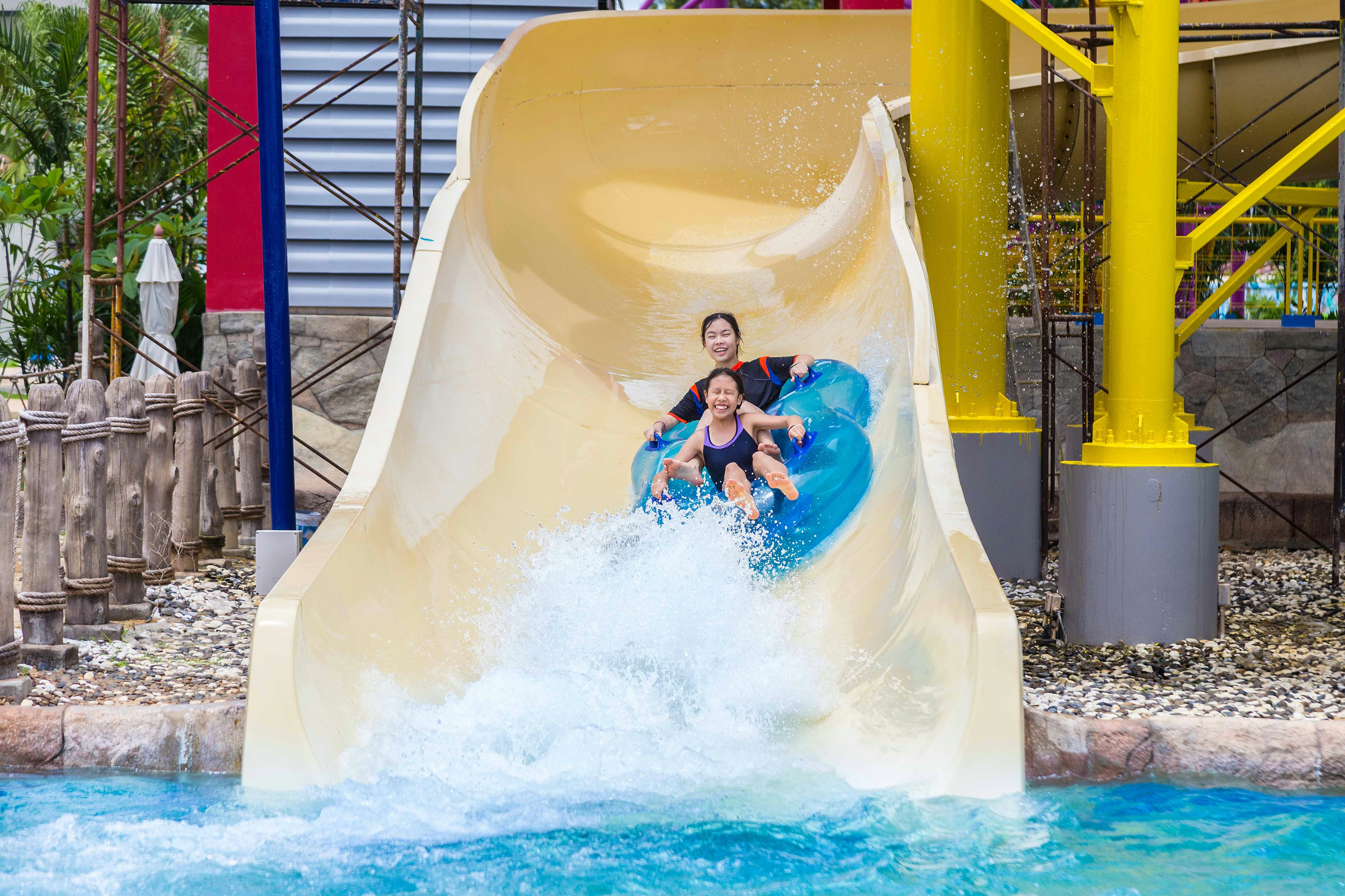 Two people enjoying the Burj Surj water slide at Wild Wadi Waterpark, Dubai.
