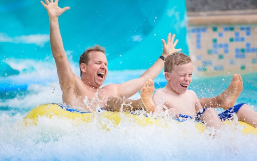Father and son enjoying a water slide at Aquafan Waterpark.