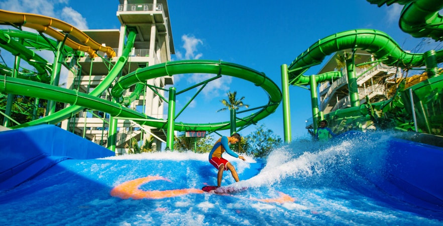 Boy surfing on Flow Rider at Waterbom Bali water park, Indonesia.