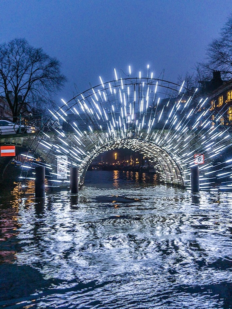 Amsterdam Light Festival installation on canal bridge during New Year celebrations.
