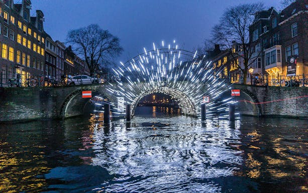 Amsterdam Light Festival installation on canal bridge during New Year celebrations.