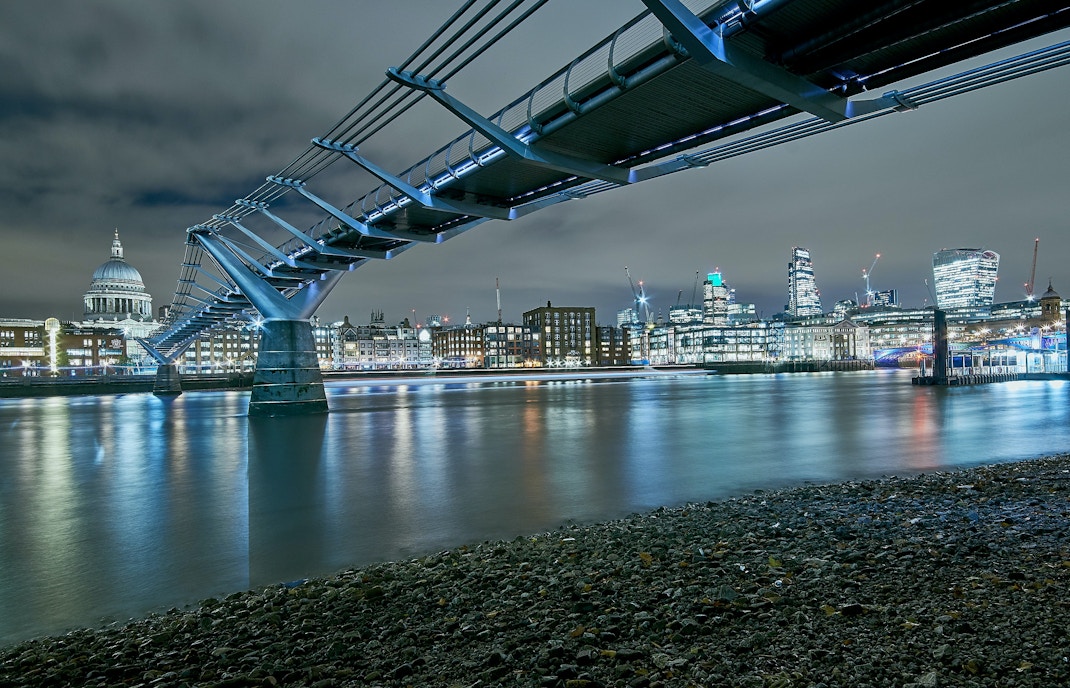Millennium Bridge spanning the Thames River with St. Paul's Cathedral in the background, London.