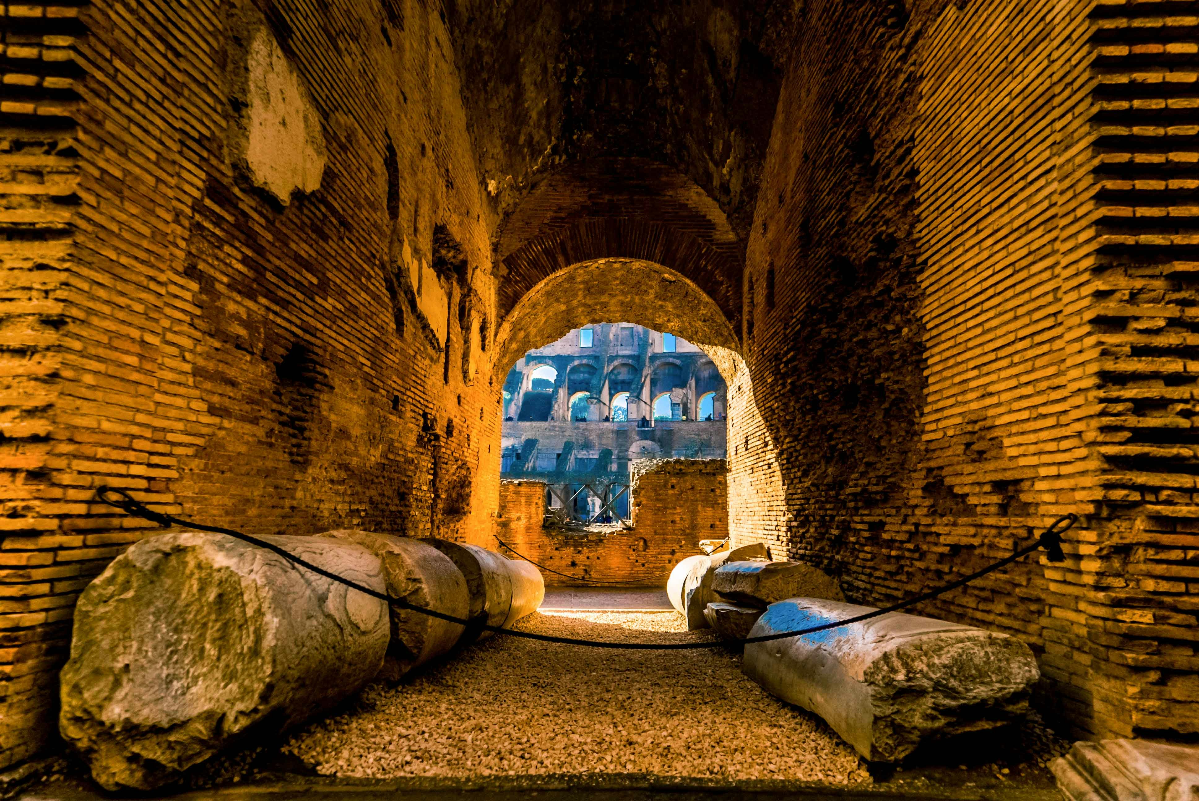 Interior view of the Colosseum at night with ancient stone columns, Rome.