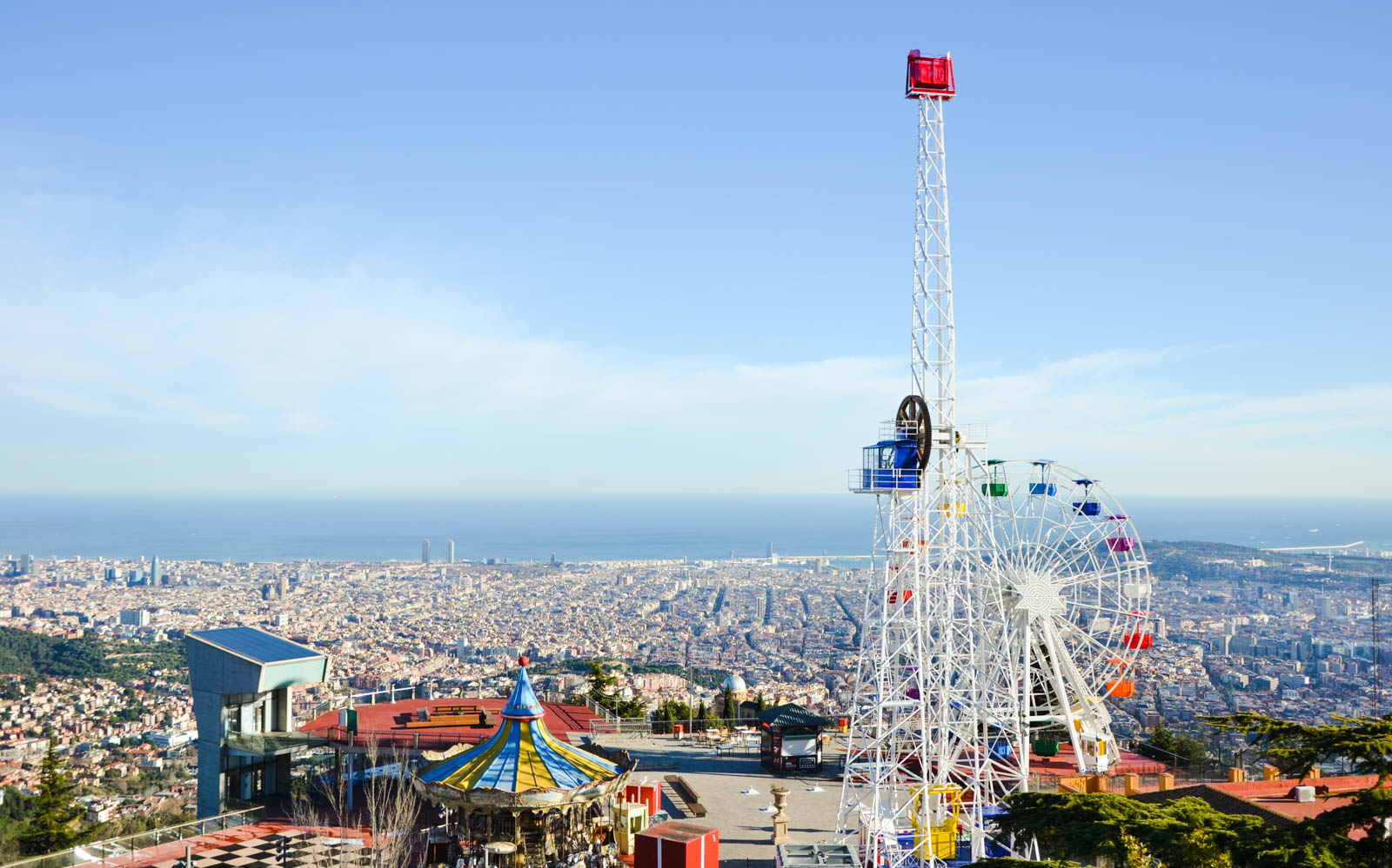 Tibidabo Amusement Park Ferris wheel overlooking Barcelona cityscape.