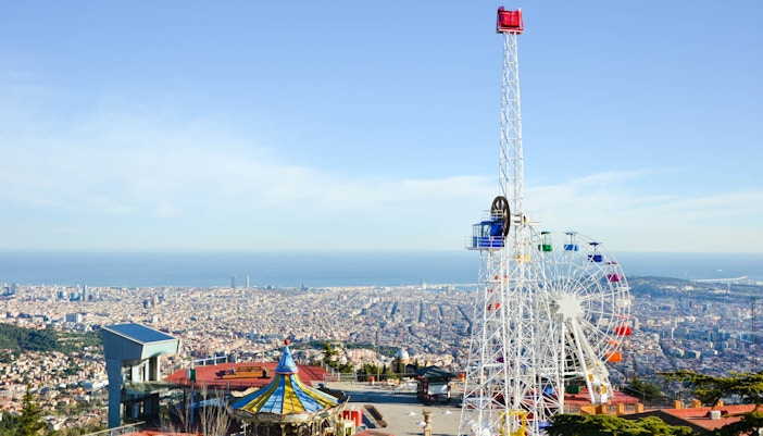 Tibidabo Amusement Park Ferris wheel overlooking Barcelona cityscape.