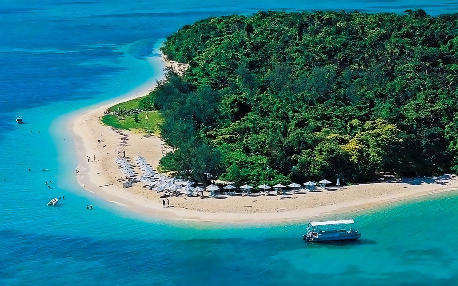 Catamaran cruise approaching Green Island, Great Barrier Reef, with semi-submarine tour option.