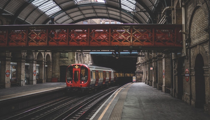 London Tube train arriving at a bustling underground station in London, England.