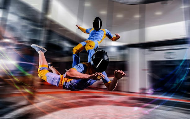 Participant in flight gear experiencing indoor skydiving at iFly Dubai.