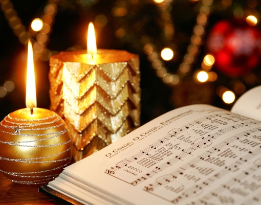 Christmas carol sheet music with lit candles in Amsterdam.