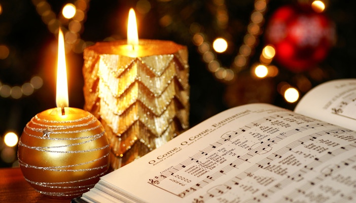 Christmas carol sheet music with lit candles in Amsterdam.