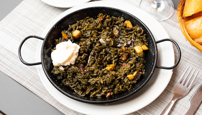 Paella negra dish with seafood, a popular culinary experience in Barcelona.