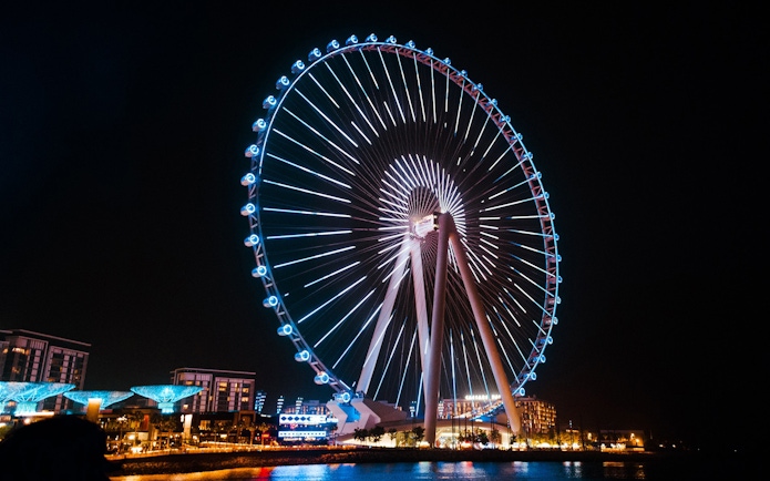 Ferris wheel illuminated at night on Bluewaters Island, Dubai.
