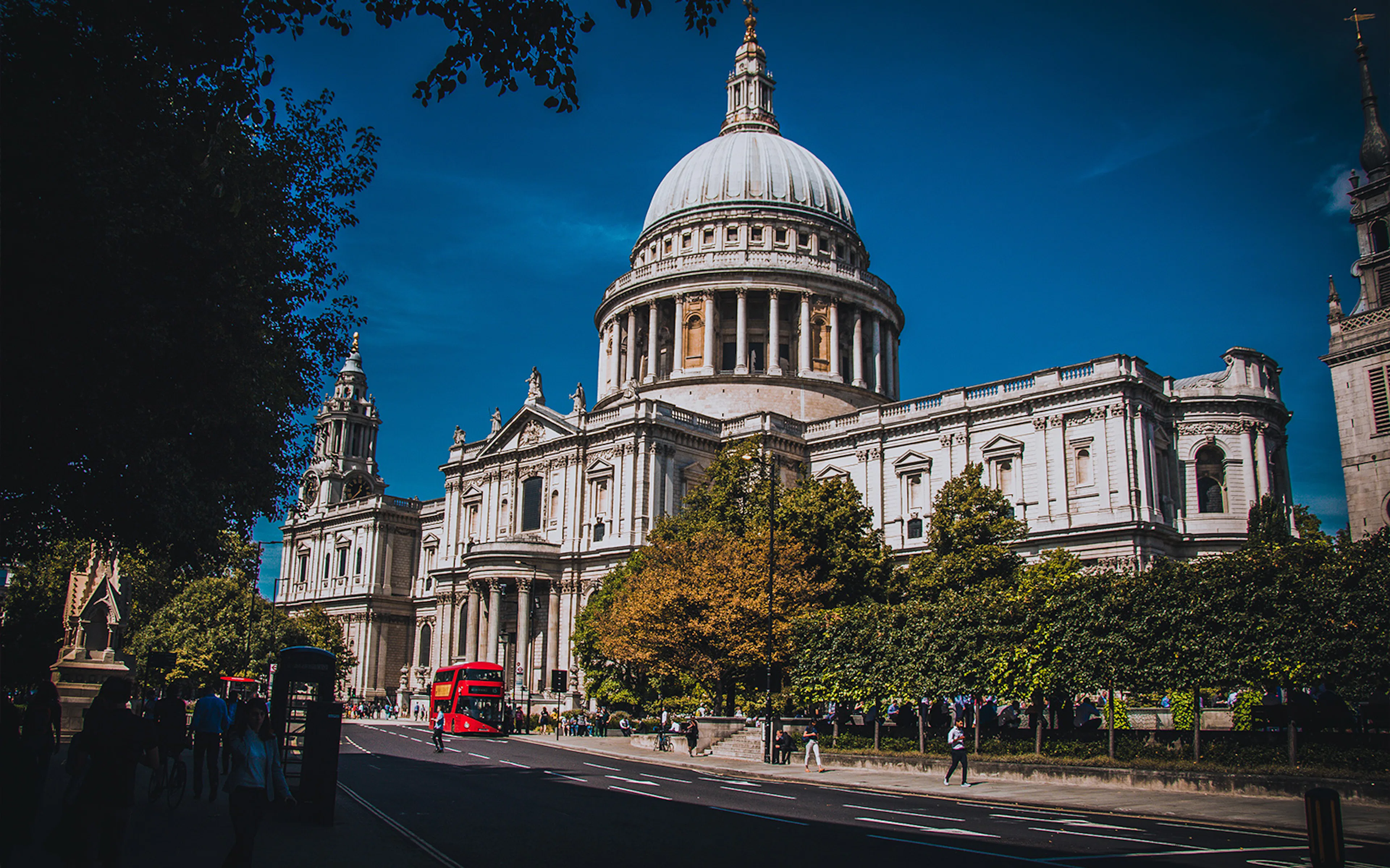 St Paul’s Cathedral dome with red double-decker buses on the street, London.