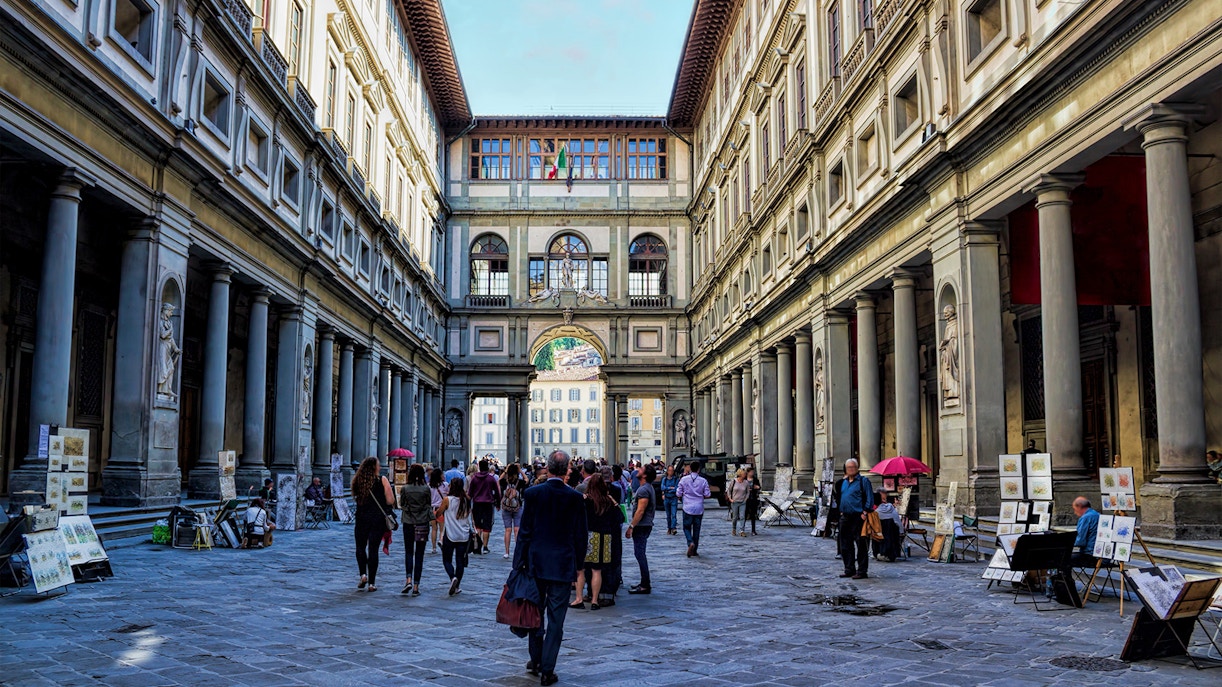 Eager art lovers walk through the historic corridor of Uffizi Gallery, a scene where 'skip the line' tickets promise immediate access to Renaissance masterpieces