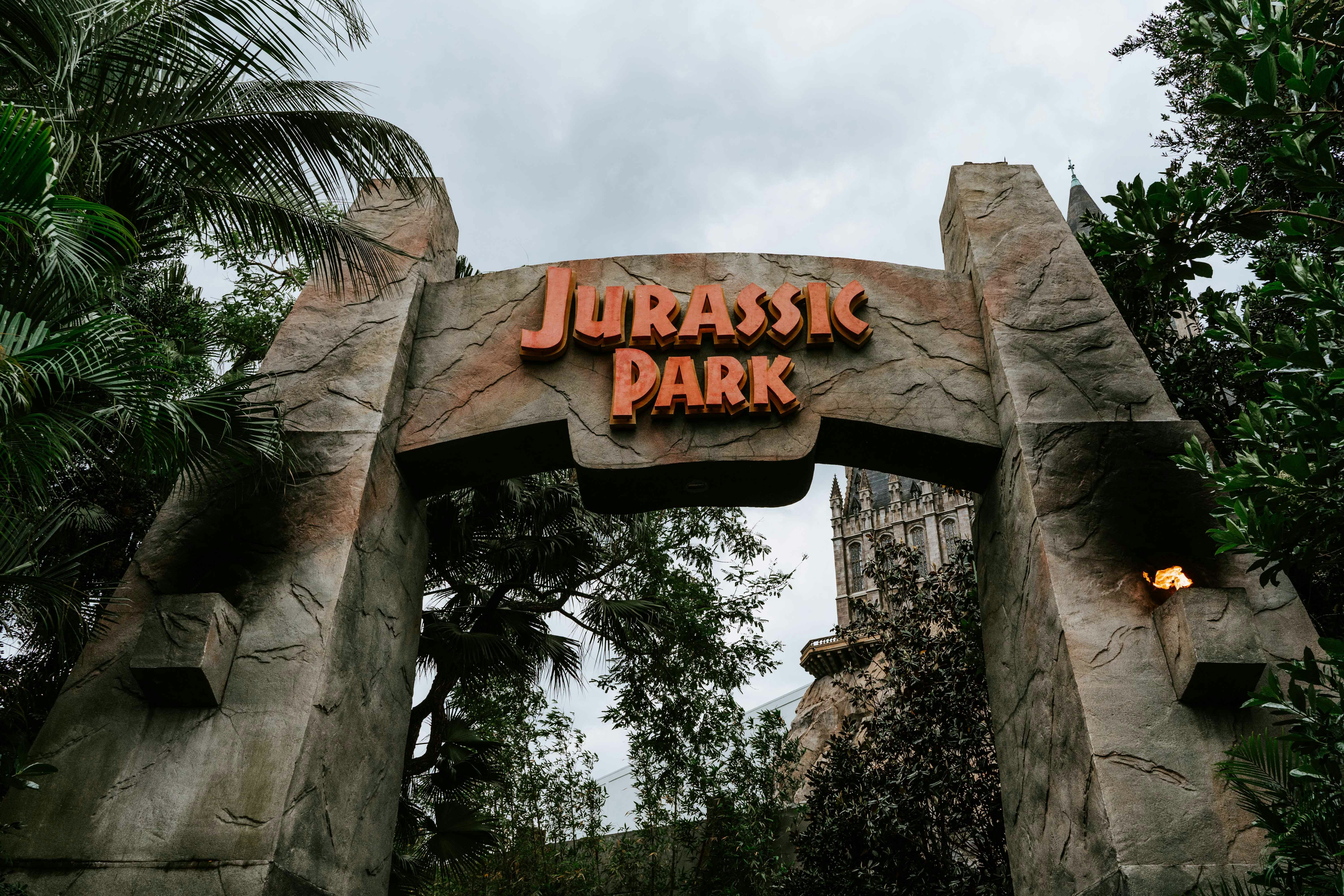 Entrance archway to Jurassic Park at Universal Studios Japan, surrounded by lush greenery.