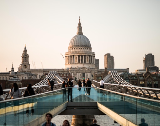 Millennium Bridge leading to St Paul’s Cathedral in London at sunset.