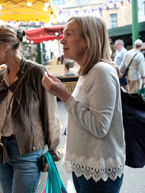 Visitors sampling cheese at a market stall during a London food tour.