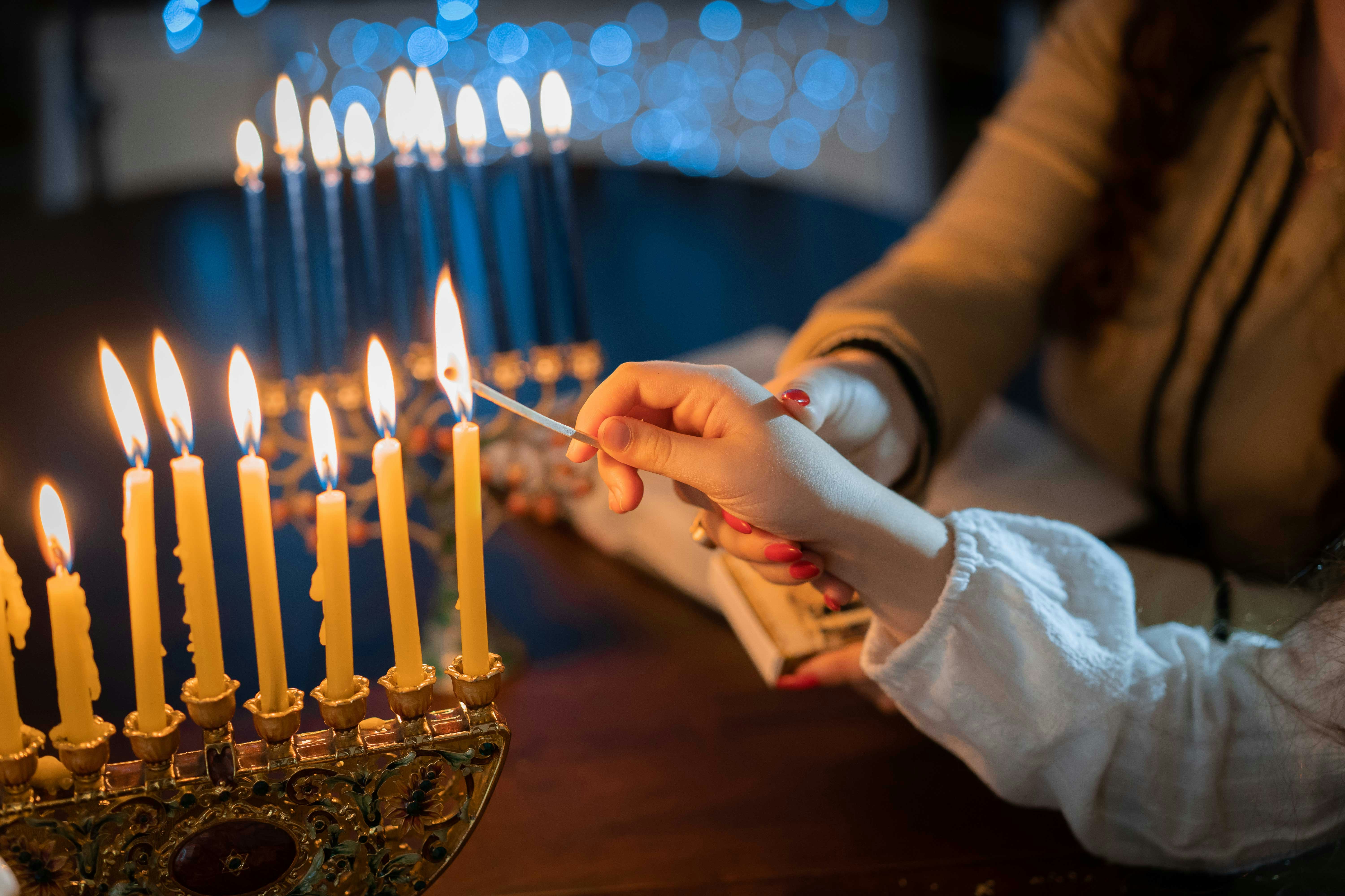 Lighting Hanukkah menorah candles in Rome during holiday season.