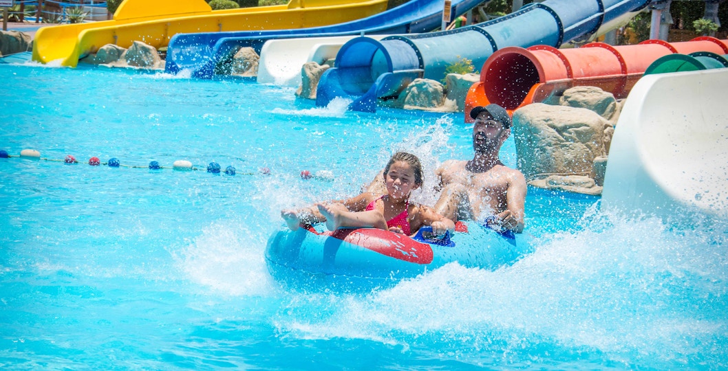 Family enjoying water slide at Aquaboulevard, Paris.