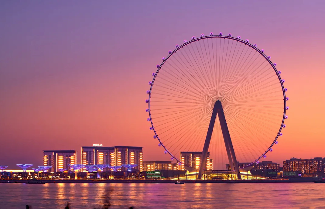 Ain Dubai Ferris wheel at sunset with city lights, Dubai.