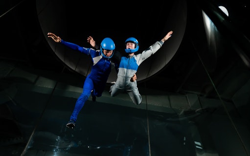 Indoor skydiving at iFly Singapore with view of Sentosa Island.