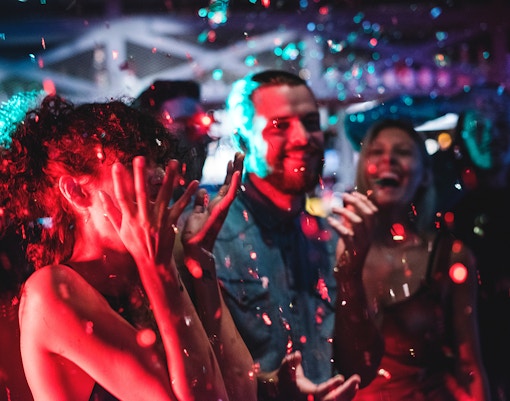 People celebrating New Year in Amsterdam with confetti and lights.