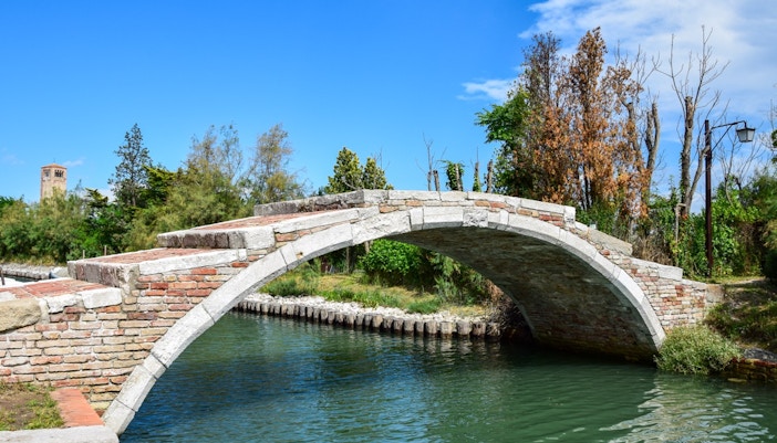 Ponte del Diavolo, historic stone bridge over canal in Torcello, Italy.