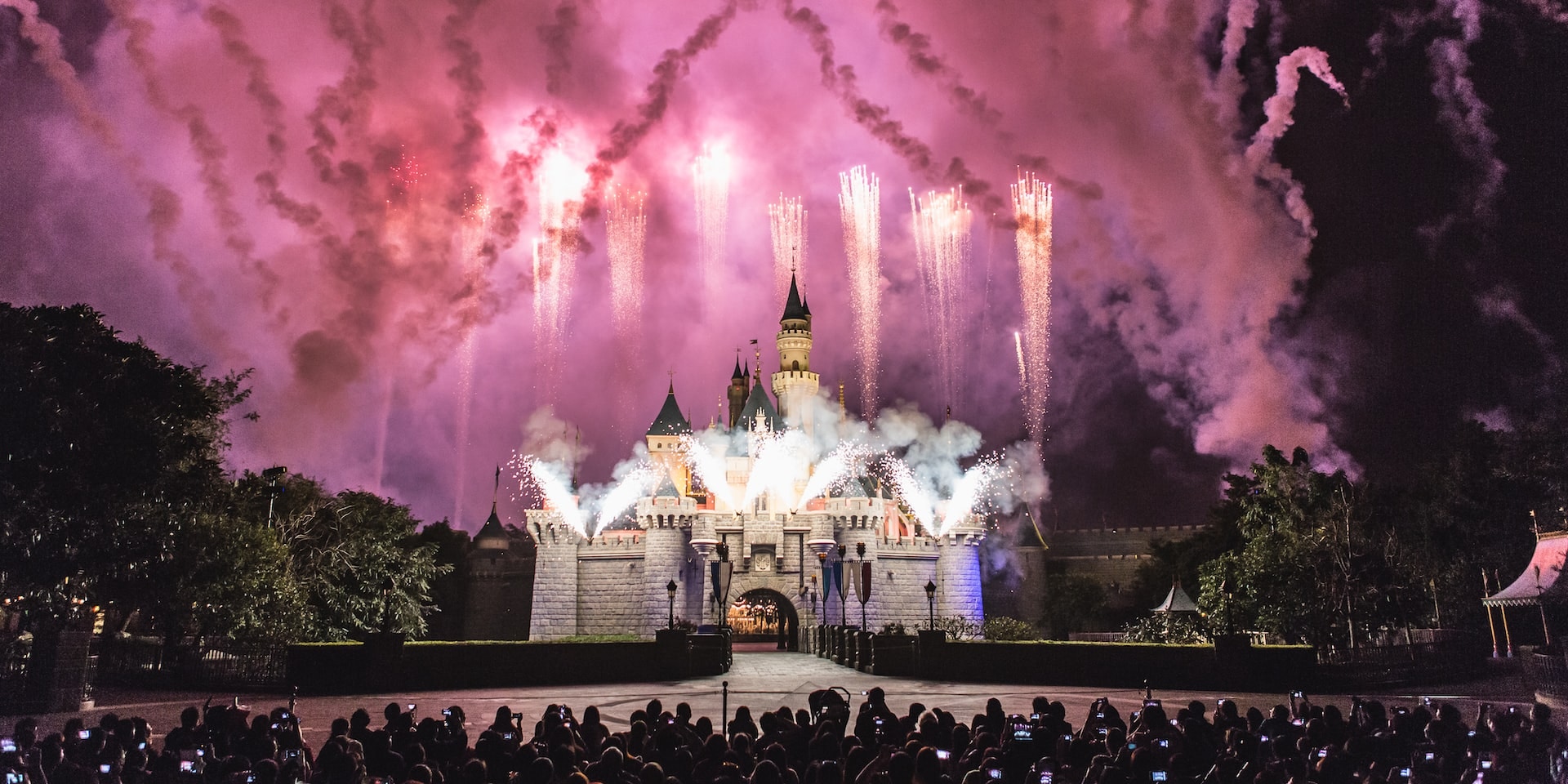 Fireworks display over Sleeping Beauty Castle during Disney Illuminations show.