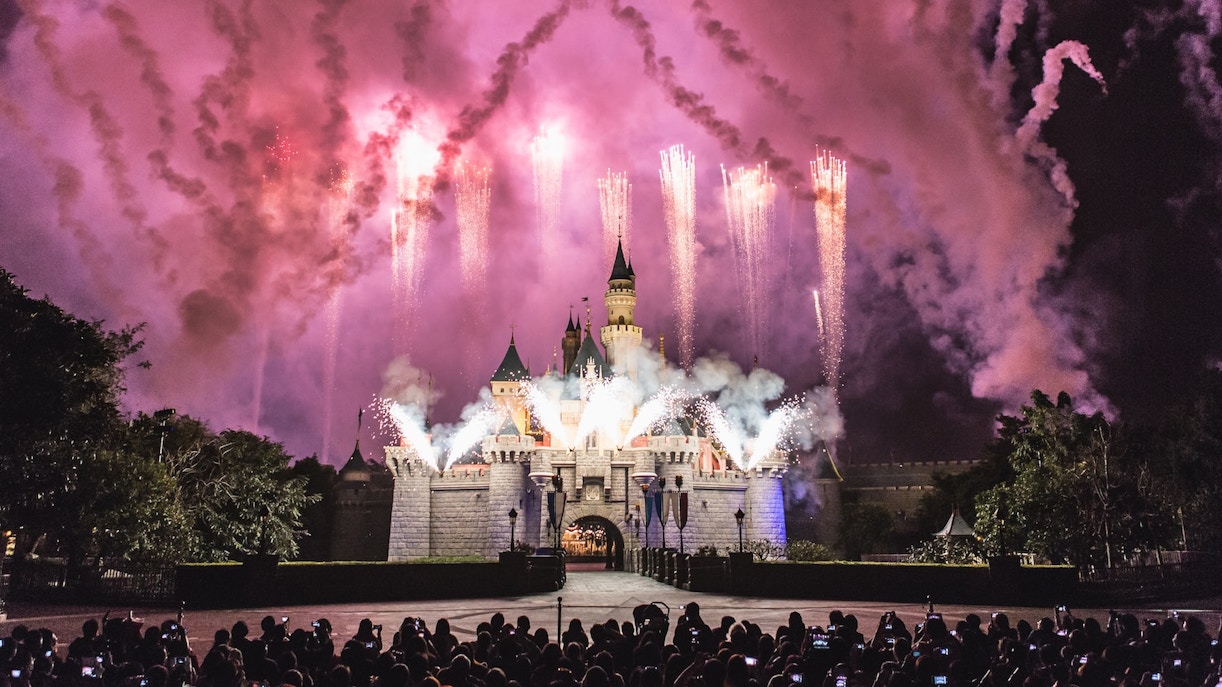 Fireworks display over Sleeping Beauty Castle during Disney Illuminations show.