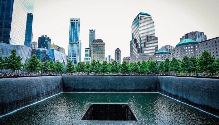 Reflecting pool at 9/11 Memorial Museum, New York City, with surrounding skyscrapers.