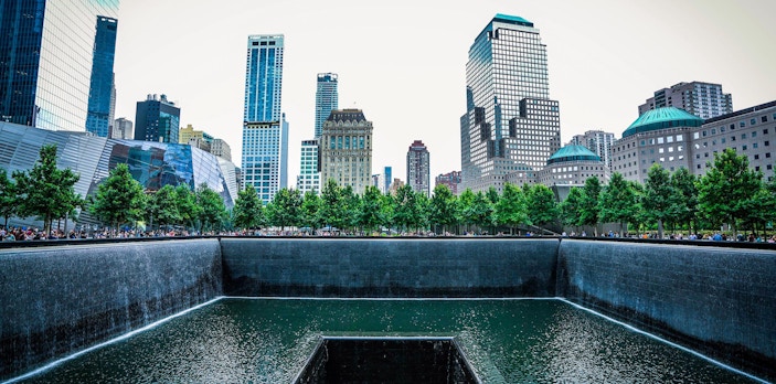 Reflecting pool at 9/11 Memorial Museum, New York City, with surrounding skyscrapers.