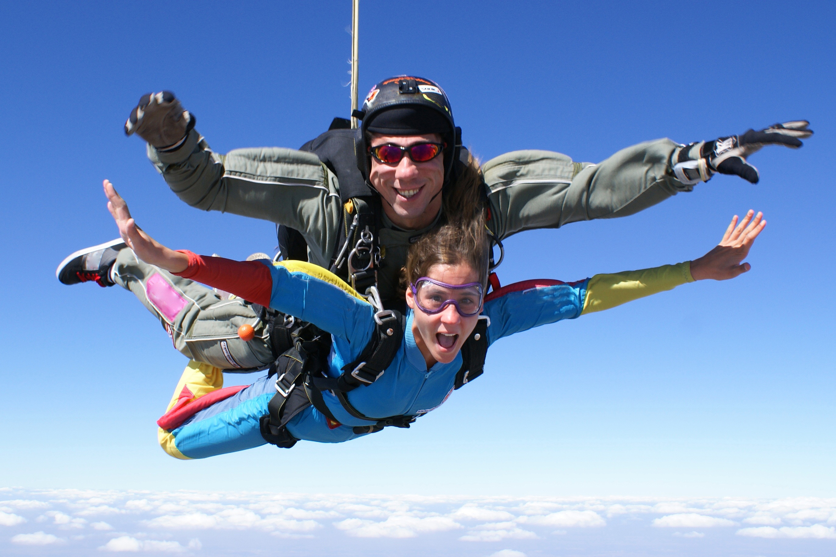 Skydivers tandem jumping over Gold Coast with clear blue sky.