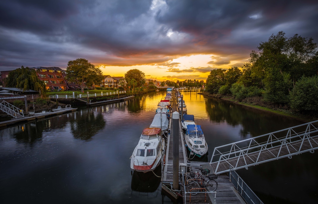 Boats docked at Teddington Lock during sunset on the Hampton Court boat ride.
