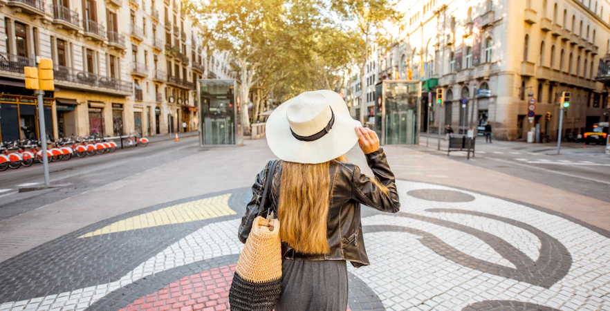 Woman walking on Barcelona's La Rambla with mosaic art underfoot.