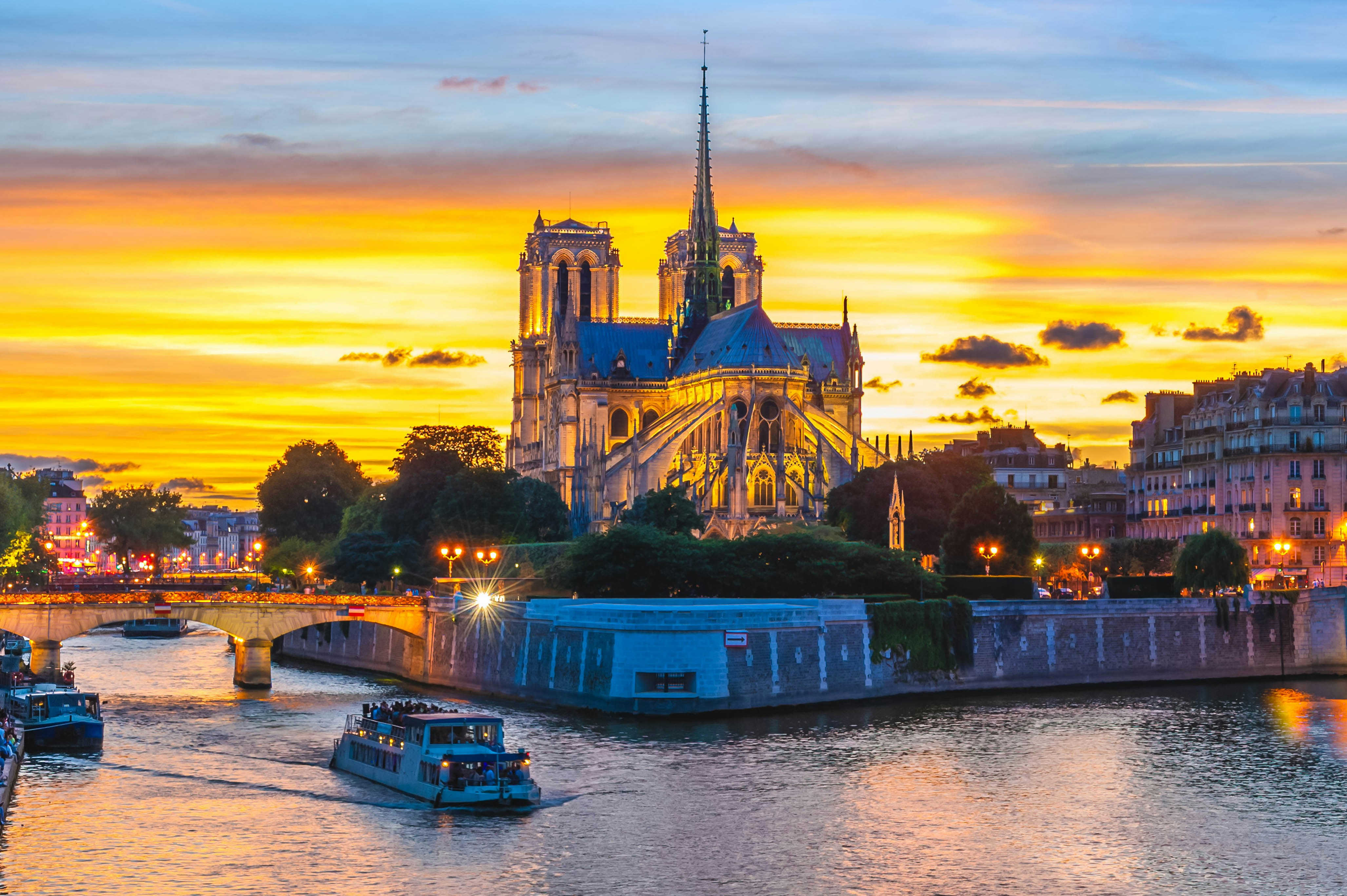 Seine River cruise with illuminated Eiffel Tower in Paris at night.