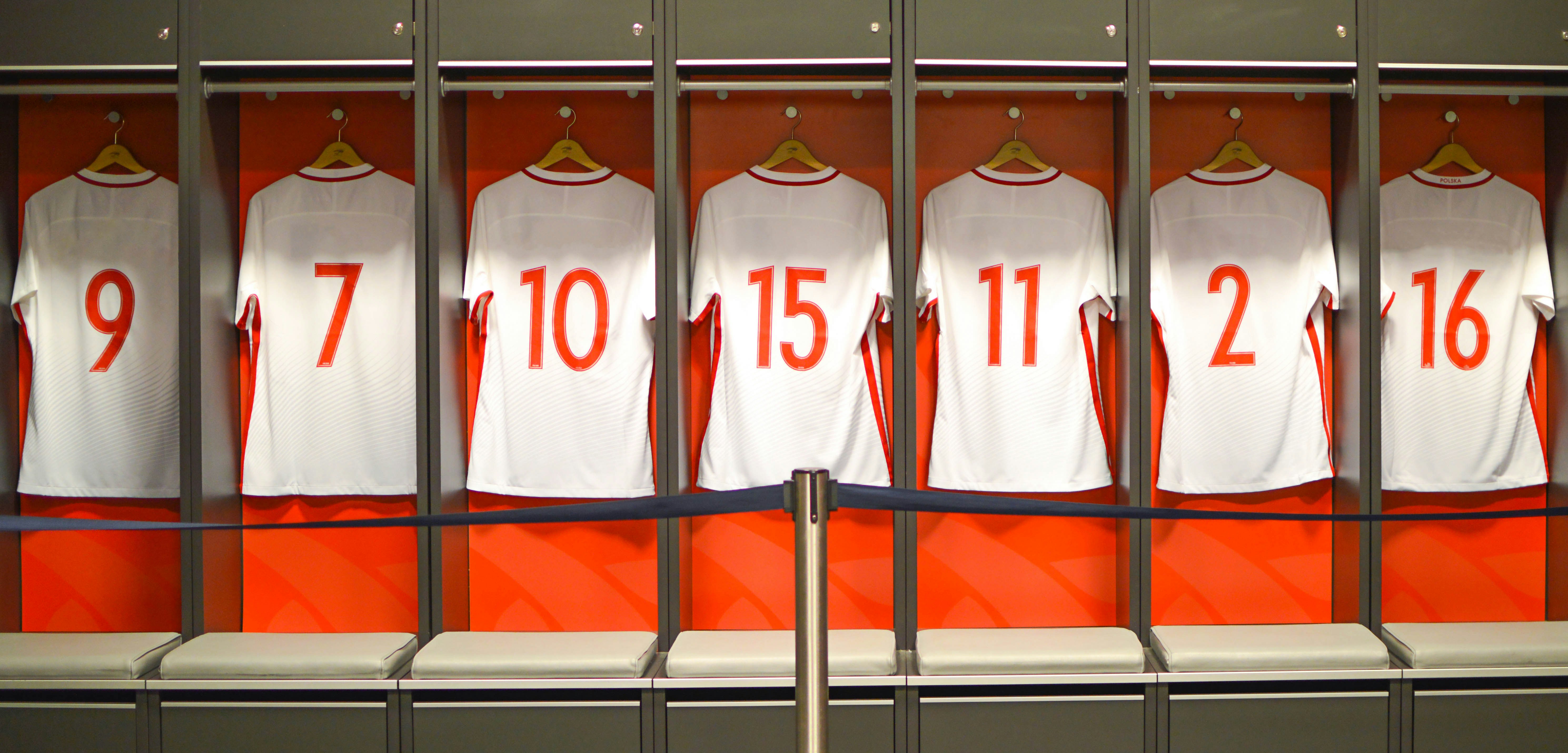 Arsenal FC Emirates Stadium locker room with numbered jerseys displayed.