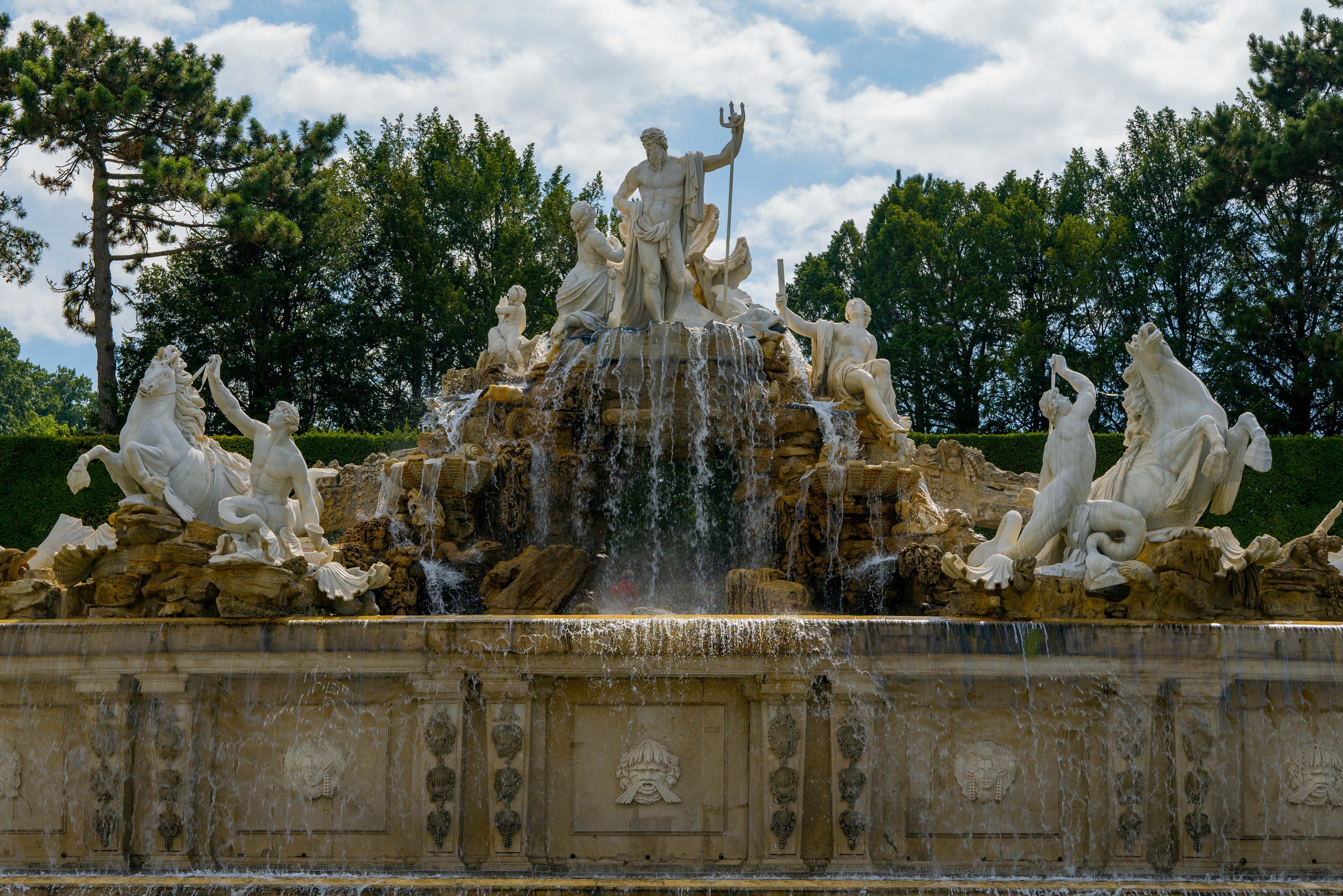 Neptune Fountain at Schonbrunn Palace, Vienna, with cascading water and statues.