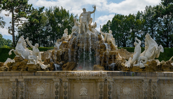 Neptune Fountain at Schonbrunn Palace, Vienna, with cascading water and statues.