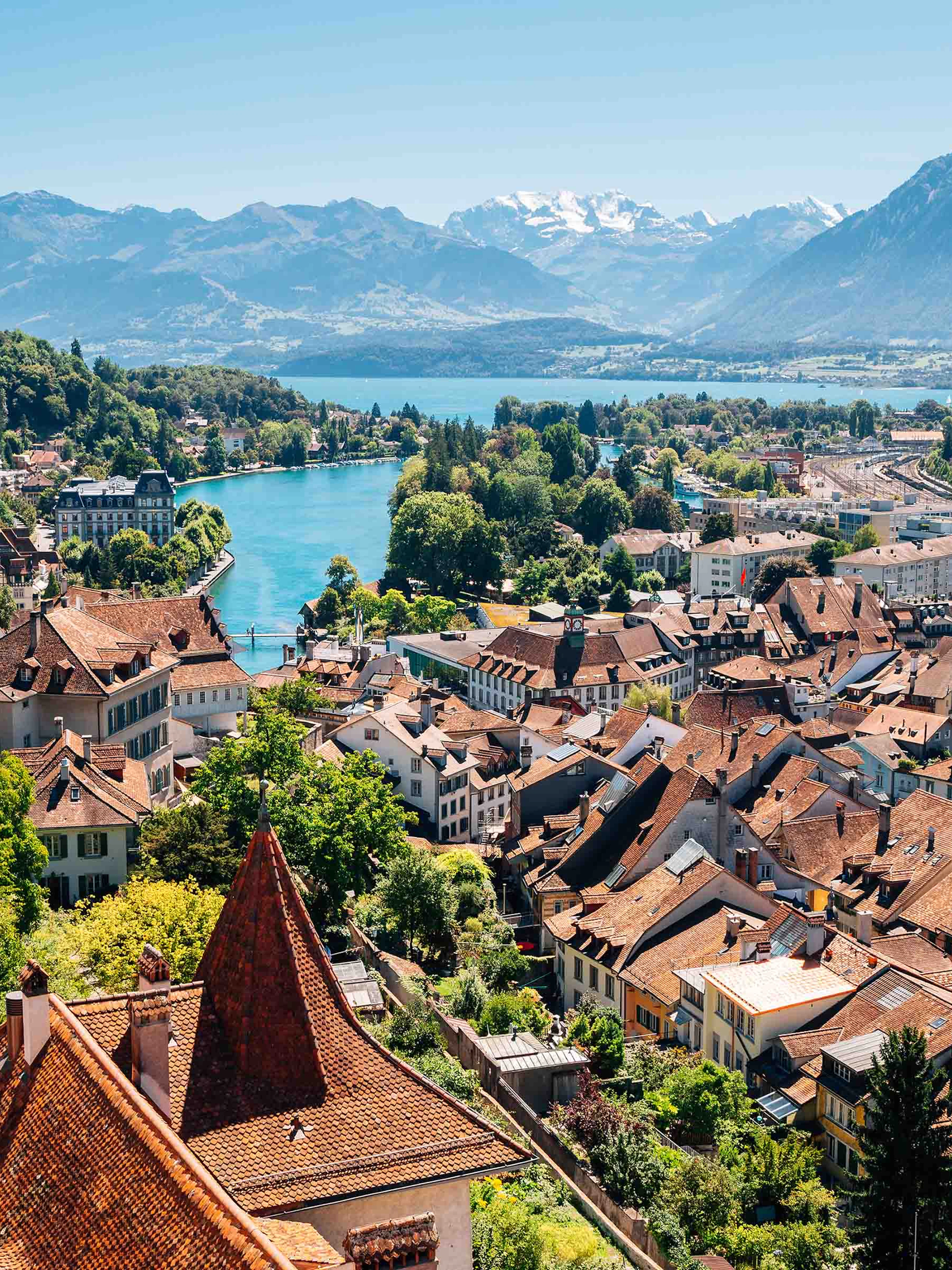 Aerial view of Interlaken with historic buildings, church, and mountains in the background.
