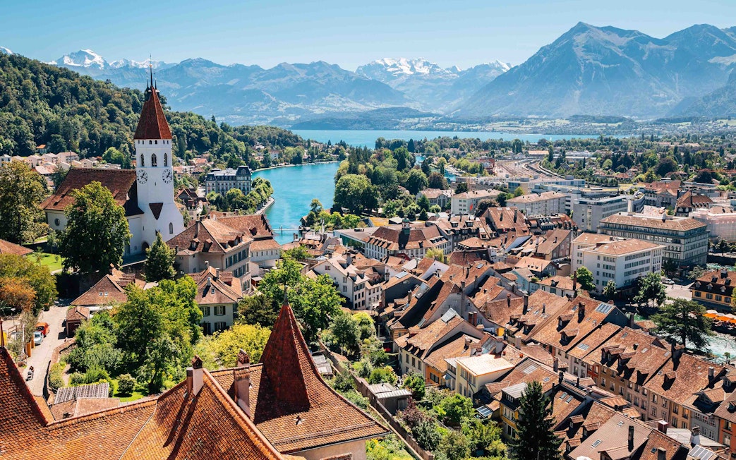 Aerial view of Interlaken with historic buildings, church, and mountains in the background.