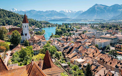 Aerial view of Interlaken with historic buildings, church, and mountains in the background.