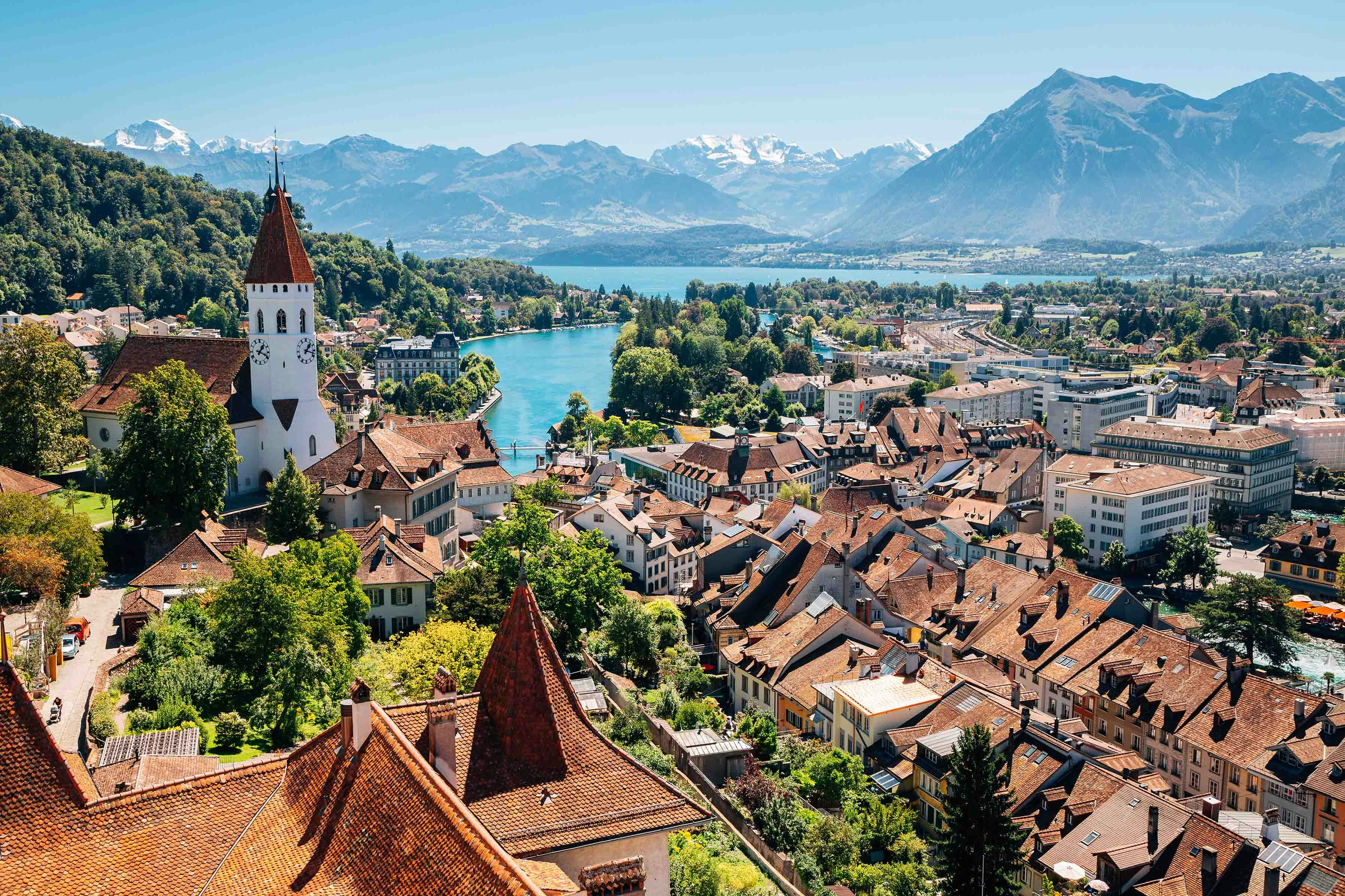 Aerial view of Interlaken with historic buildings, church, and mountains in the background.