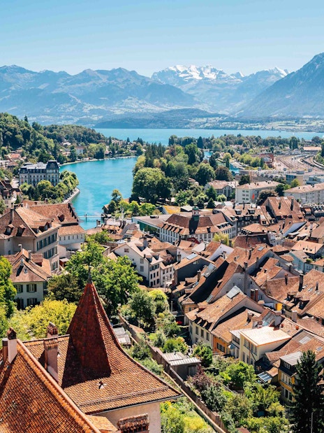 Aerial view of Interlaken with historic buildings, church, and mountains in the background.