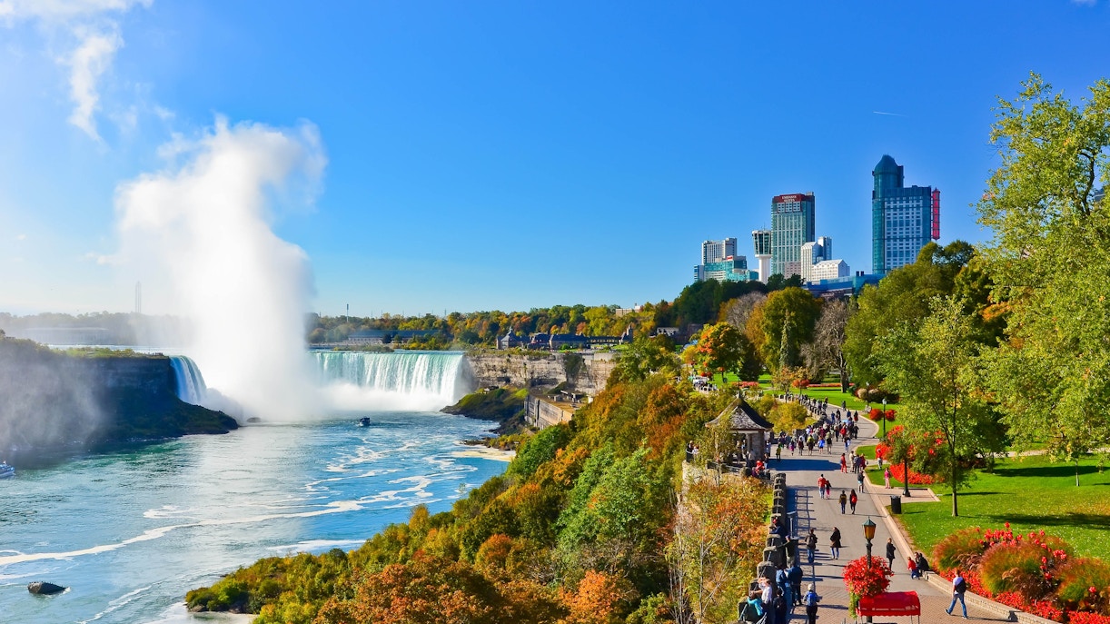 Niagara Falls view with tourists on a boat tour, part of New York to Niagara Falls Tours.