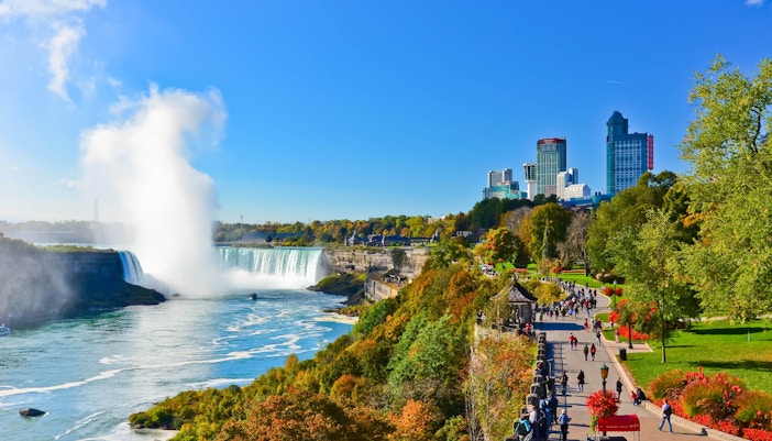 Niagara Falls view with tourists on a boat tour, part of New York to Niagara Falls Tours.q