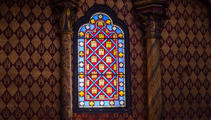 Stained glass windows inside Sainte Chapelle, Paris, showcasing biblical scenes.