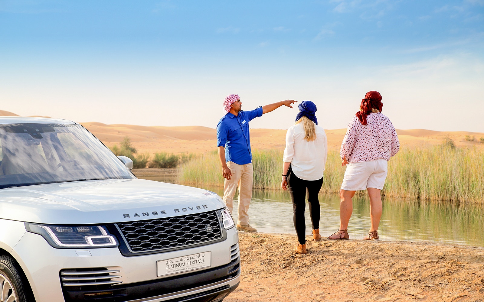 Camel ride through Dubai Desert Conservation Reserve with sand dunes in the background.