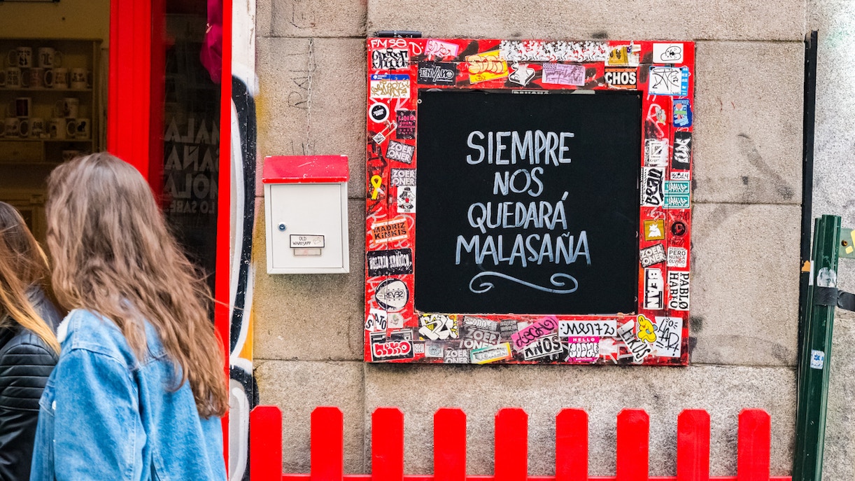 Chalkboard with "Siempre nos quedará Malasaña" in Madrid's Malasaña district.