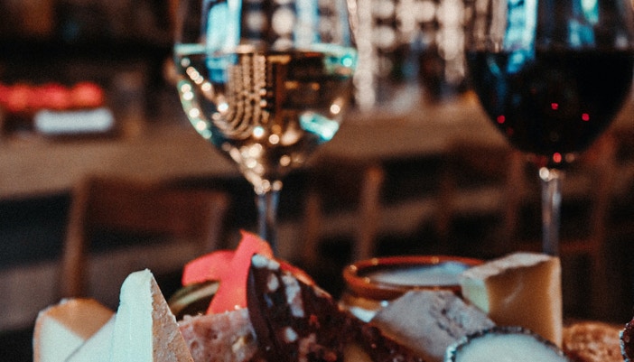 Cheese and charcuterie board with wine glasses on an Amsterdam dinner cruise.